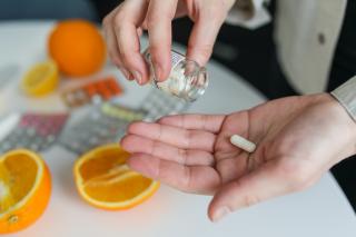 Person taking pill, background with oranges