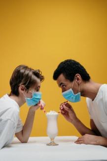 Man and woman drinking milshake wearing face masks